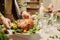 Hands of young man putting plate with roasted poultry on table