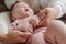 Hands of young mother calming baby down while lulling her