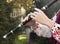 Hands of a young musician play on a wooden flute. A man in a Bulgarian national costume plays on a long pipe