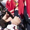 Hands of a young musician play on a wooden flute. A man in a Bulgarian national costume plays on a long pipe