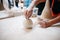 Hands of young potter, was produced on range Hands of a potter skillfully making a pot of white clay