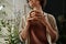 Hands of young serene woman in home wear holding cup of tea