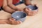 Hands of young starving african american wife and husband holding empty plates at table in kitchen