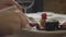 The hands of the young woman cutting tasty fresh meat lying on the plate with the vegetable using fork and knife close