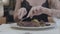 Hands of young woman cutting tasty steak lying with vegetables and leaves on the plate in the restaurant. Alcohol glass