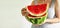 The hands of a young woman hold a piece of ripe juicy watermelon on a light background. The taste of summer. Fruits and vegetables