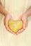 Hands of young woman holding potato in heart shape