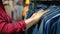 Hands of a young woman shopper in a denim clothing store