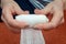 Hands of a young woman unwind a roll of a medical gauze bandage. Frontal close-up view. Selective focus