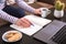 Hands of a young woman, who are online studying and working, surrounded by laptop and cactus. Casual wearing