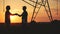 handshake agriculture. silhouette two farmers sign a contract shake hands on the background of an irrigation machine in
