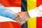Handshake on Belgium and Austria flag background