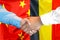 Handshake on Belgium and China flag background