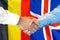 Handshake on Belgium and Iceland flag background