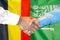 Handshake on Belgium and Saudi Arabia flag background