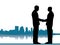 Handshake of a business deal with city skyline