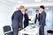 Handshake business people. A group of businessmen at desk in mo