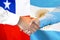 Handshake on Chile and Argentina flag background