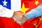 Handshake on Chile and China flag background