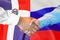 Handshake on Dominican Republic and Russia flag background. Support concept