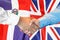 Handshake on Dominican Republic and UK flag background. Support concept