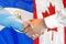 Handshake on El Salvador and Canada flag background. Support concept