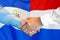 Handshake on El Salvador and Dutch flag background. Support concept