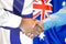 Handshake on Finland and Australia flag background