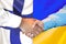 Handshake on Finland and Ukraine flag background