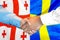 Handshake on Georgia and Sweden flag background