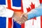 Handshake on Iceland and Canada flag background
