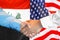 Handshake on Iraq and US flag background. Men handshake on the background of the Iraq and United States of America flag. Support