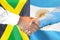 Handshake on Jamaica and Argentina flag background