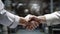 A handshake between men in white shirts in the industrial interior of a factory or enterprise.