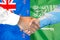 Handshake on New Zealand and Saudi Arabia flag background