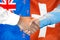 Handshake on New Zealand and Switzerland flag background