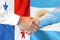 Handshake on Panama and Argentina flag background