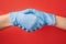 Handshake in rubber medical gloves.