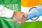 Handshake on Saudi Arabia and India flag background