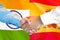 Handshake on Spain and India flag background