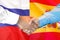 Handshake on Spain and Russia flag background