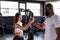 Handshake of sporty african man with woman greeting partner exercise workout at fitness gym.