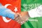 Handshake on Turkey and Saudi Arabia flag background