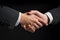 Handshake of two businessmen on black background, Businessman handshake close-up, top section cropped, No hand deformation, AI