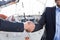 Handshake of two businessmen near the yachts in seaport