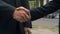 Handshake of two businesspeople standing near office, agreement, partnership