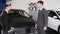 Handshake of two men on new car background. Close up of men greeting with handshake. Business partners handshaking