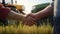 handshake of two men in shirts against the background of a field with two harvesters