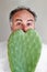 Handsom bearded mature man holds a heart-shaped cactus in the pot. Portrait with funny romantic facial expression.