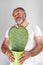 Handsom bearded mature man holds a heart-shaped cactus in the pot. Portrait with funny romantic facial expression.